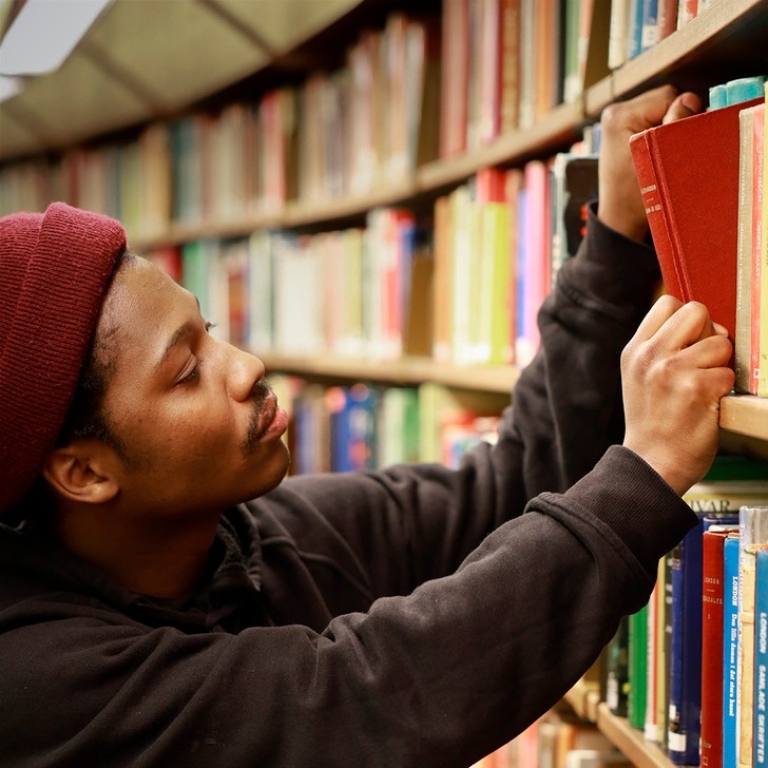 Man taking out book from shelf