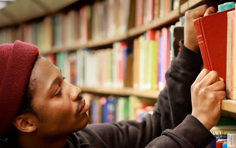 Man taking out book from shelf