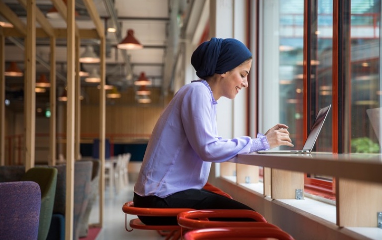 Picture of woman sitting by laptop